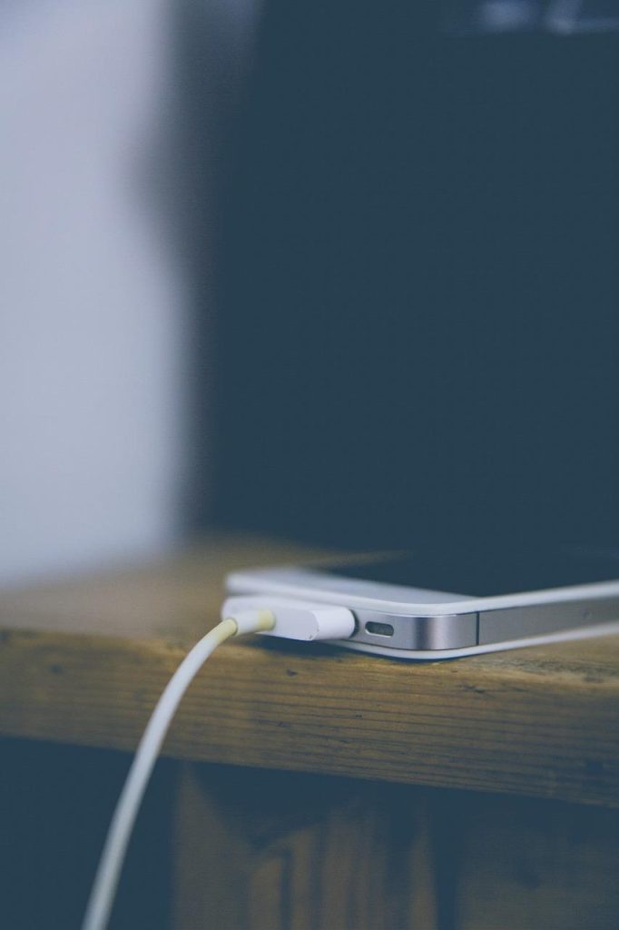 Snelle oplader voor iPhone met USB-C aansluiting en 20W vermogen naast een iPhone voor maximale laadsnelheid