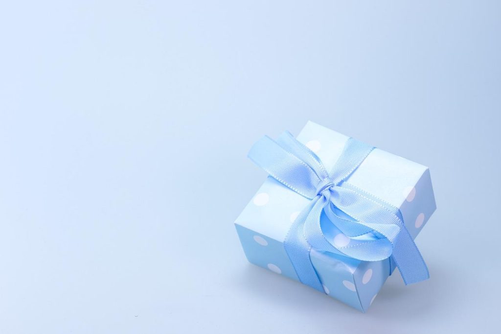 Babyshower pakket cadeau met verzorgingsproducten, speelgoed en kleding mooi verpakt in een mand met decoraties